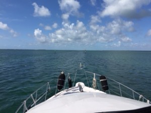 Green and red markers show the way across the shallow waters of Biscayne Bay.  Cliff is checking their numbers so we can match them up to our chart and know exactly where we are.